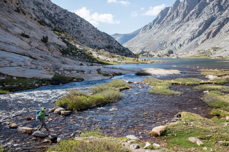 Anna rock hops across Evolution Creek in Kings Canyon National Park