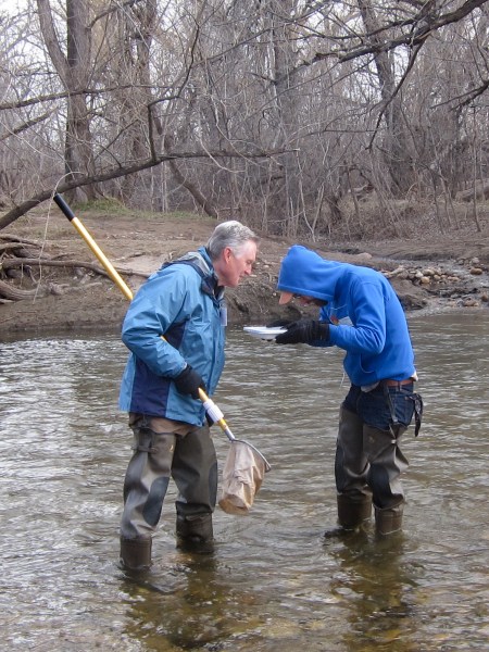 Instructor and student looking for insects in the Poudre River