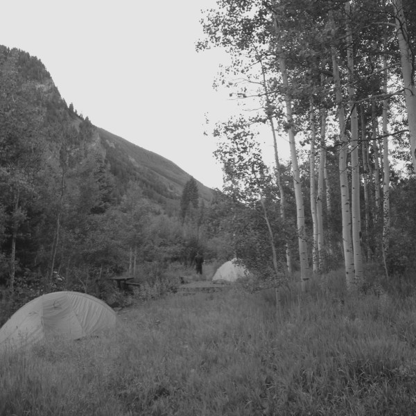 Tents near the creek under the aspen trees